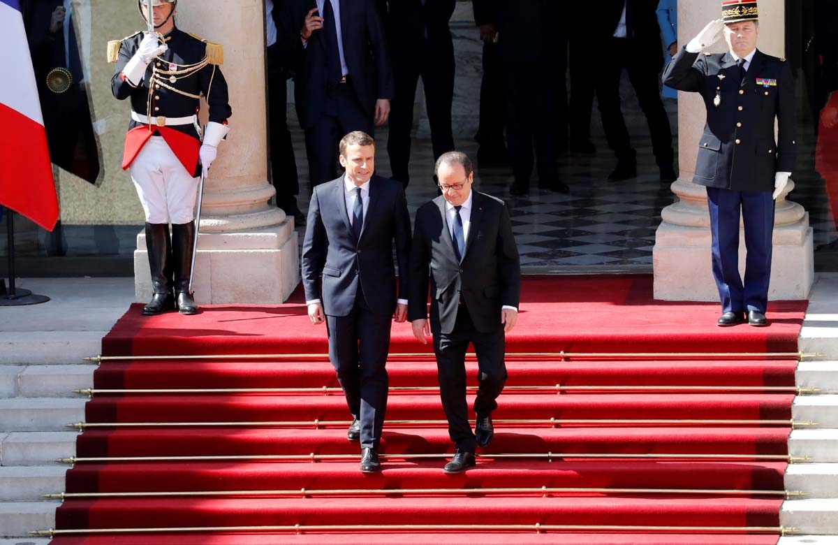 French outgoing President Francois Hollande (R) is escorted by his successor Emmanuel Macron as he leaves the Elysee presidential Palace at the end of their handover ceremony and prior to Macron's formal inauguration as French President on May 14, 2017 in