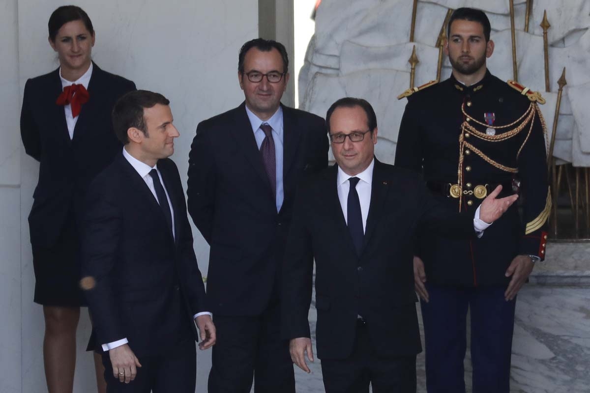 French outgoing President Francois Hollande (R) is escorted by his successor Emmanuel Macron (L) as he leaves the Elysee presidential Palace at the end of their handover ceremony and prior to Macron's formal inauguration as French President on May 14, 201