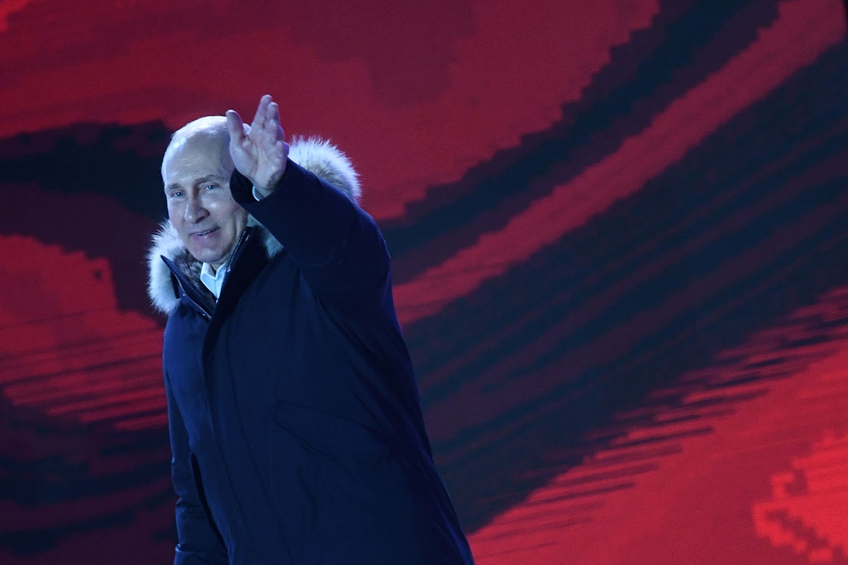 Presidential candidate, President Vladimir Putin waves as he addresses the crowd during a rally and a concert celebrating the fourth anniversary of Russia's annexation of Crimea at Manezhnaya Square in Moscow on March 18, 2018.