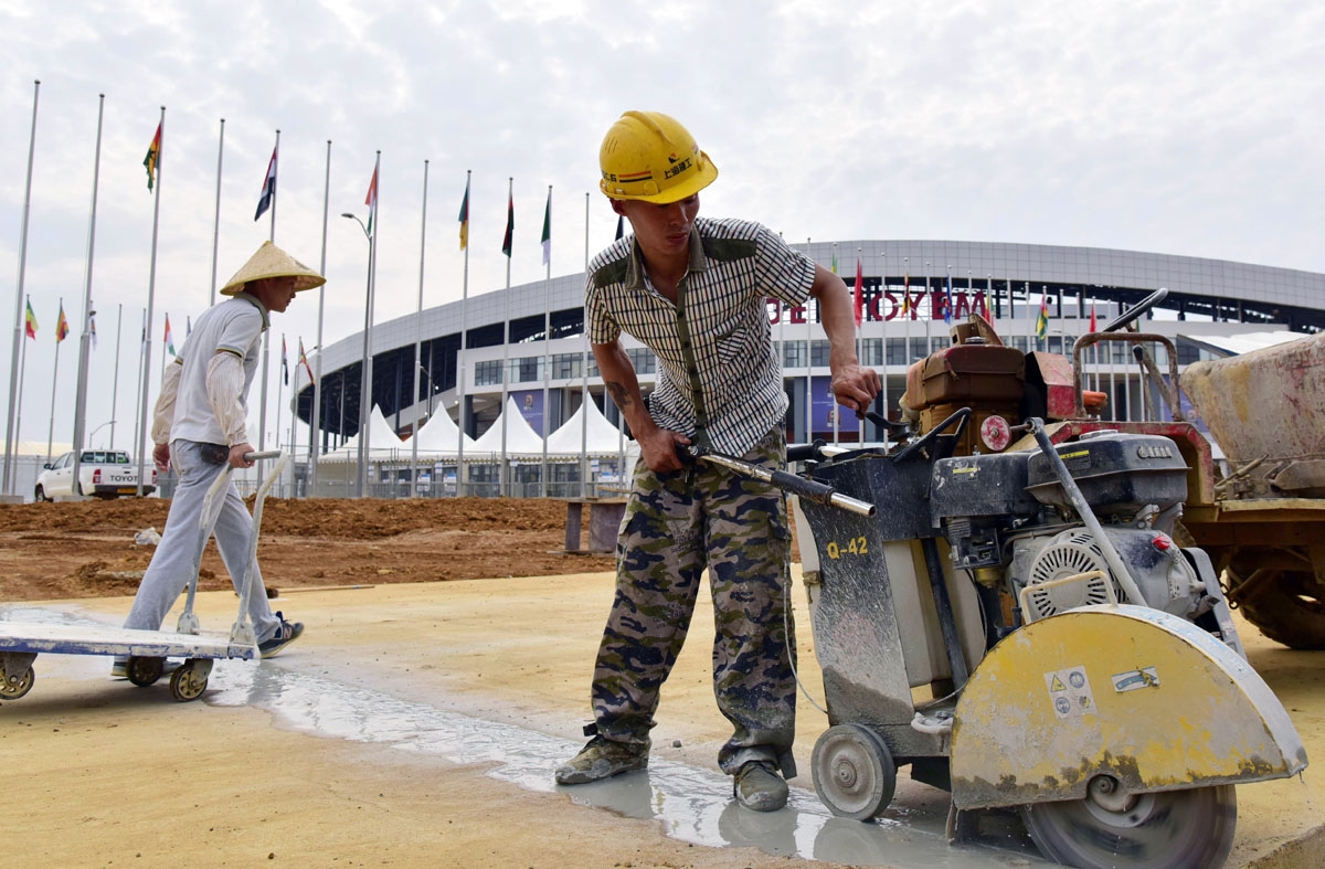 A photo taken on January 18, 2017, shows men working outside Oyem Stadium (Stade d'Oyem) one of the four stadiums hosting matches during the 2017 Africa Cup of Nations football tournament in Gabon.
