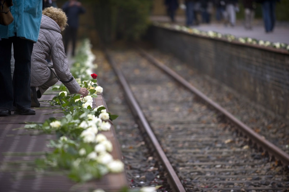 An elderly woman lays a flower at Berlin's Platform 17 memorial during a cermony marking the 70th anniversary of the departure of the first convoys carrying Jews to concentration camps from the Berlin Gruenewald station, October 18, 2011.