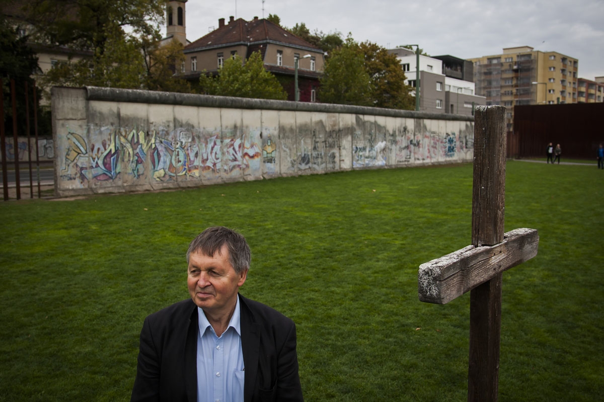 Hartmut Richter poses for pictures along remains of the 'Wall' along Bernauer strasse in Berlin on October 8, 2014. Richter fled the communist German Democratic Republic (GDR) in 1966 by swimming the Teltow canal and subsequently helped 33 other east Germ