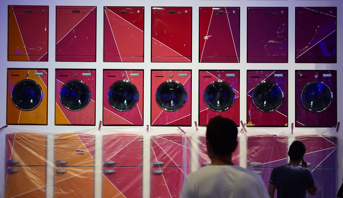Two men walk past an installation of washing machines and fridges on display at the booth of Vestel as preparations are under way for the consumer electronics fair IFA in Berlin on August 30, 2017.