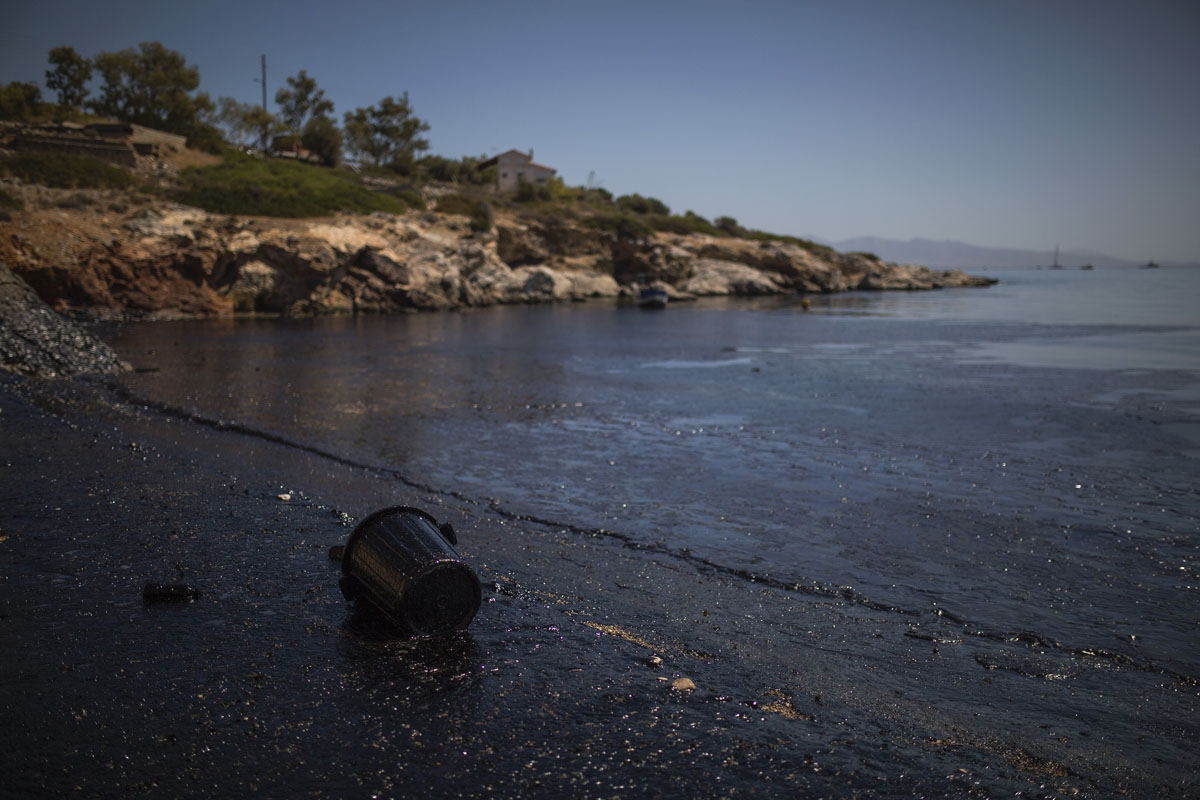 This picture taken on September 12, 2017 shows oil that has washed ashore on a beach of Salamis island near Athens, after an old tanker sank close to Salamis island over the weekend.