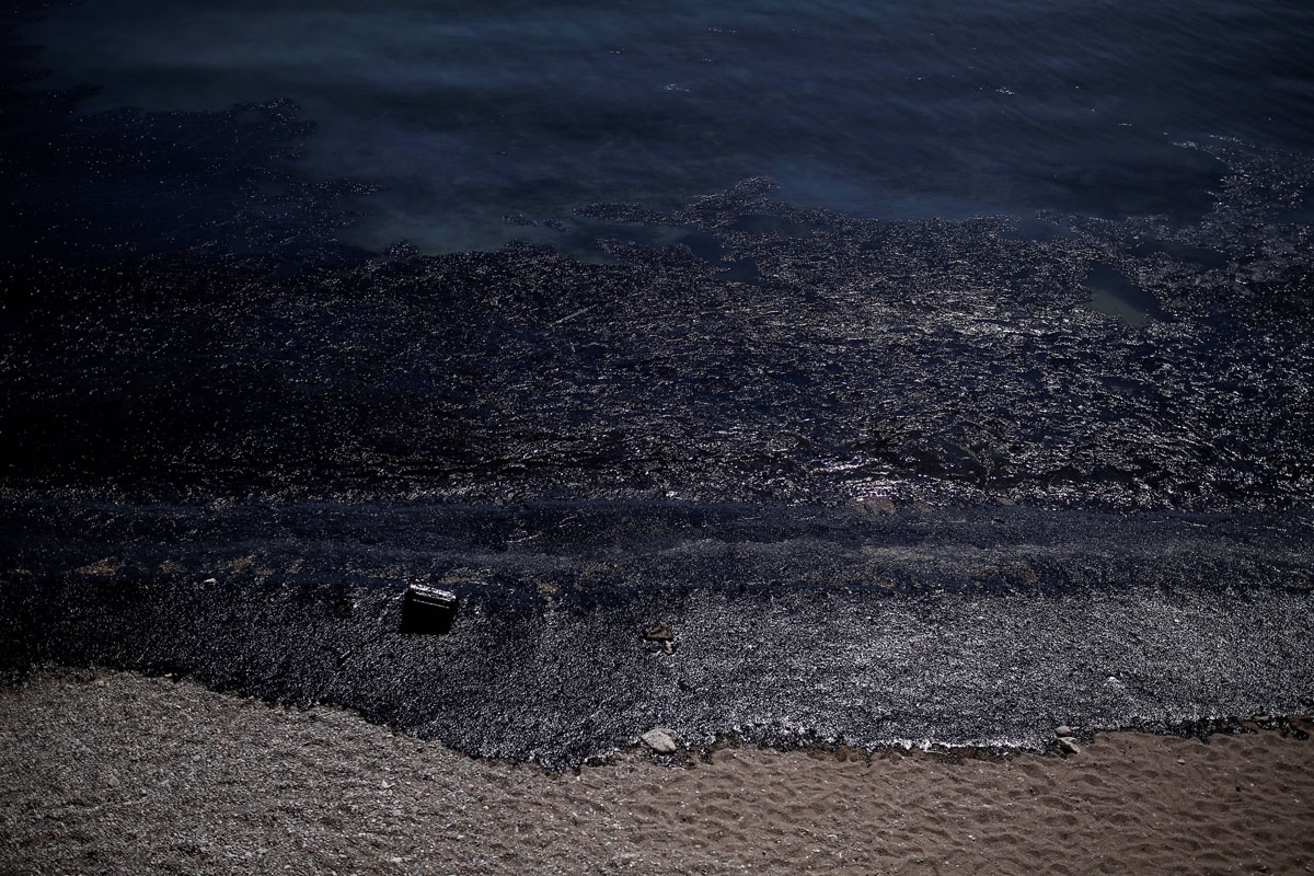 This picture taken on September 12, 2017 shows oil that has washed ashore on a beach of Salamis island near Athens, after an old tanker sank close to Salamis island over the weekend.