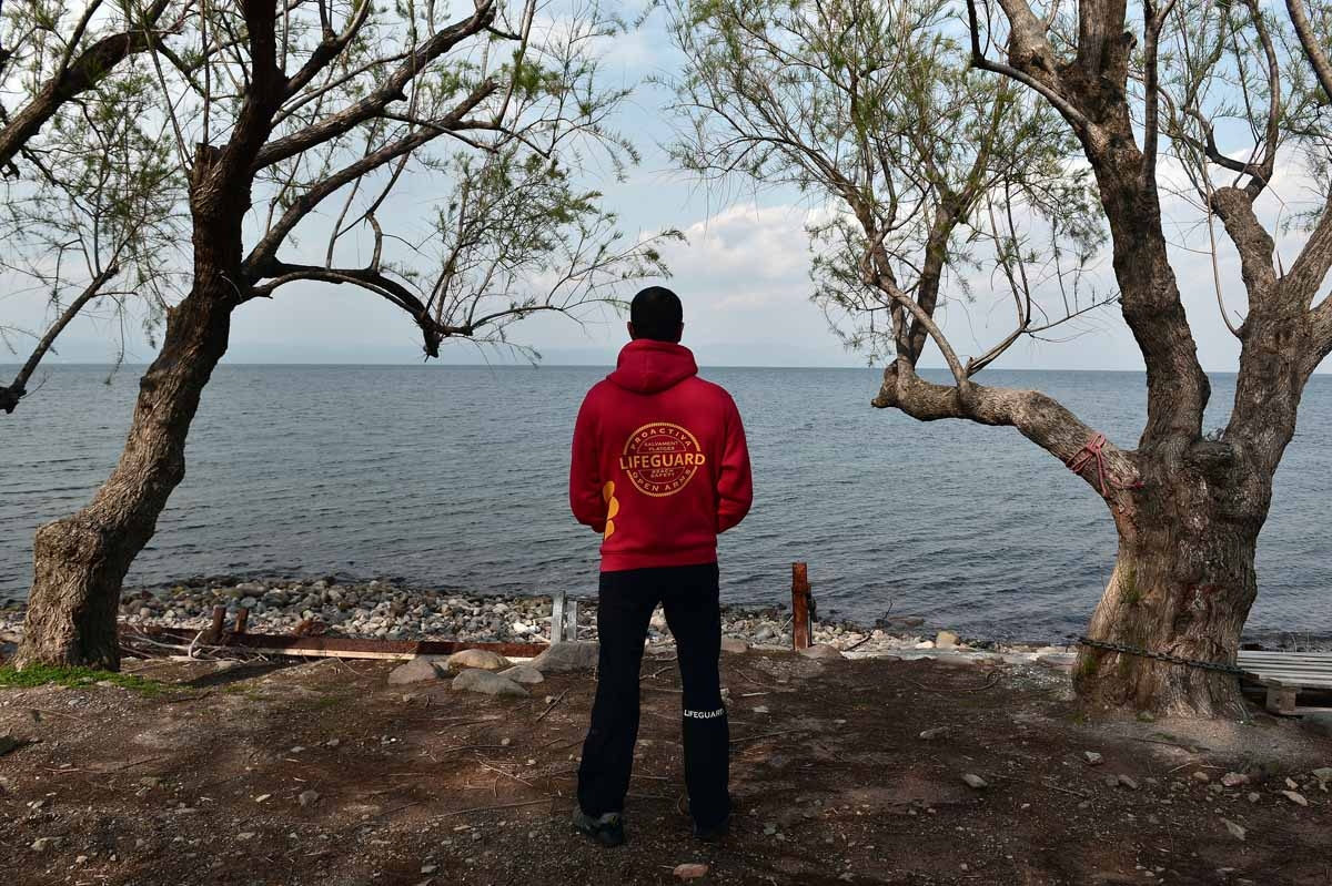 A Member of the Proactiva Open Arms rescue team looks at the sea at their base near Skala Sykamiasn on the island of Lesbos on March 15, 2017 almost a year after an EU-Turkey deal.