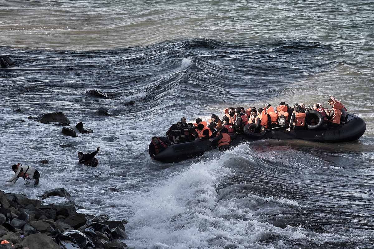 Refugees and migrants try to reach the shore on the Greek island of Lesbos, despite a rough sea, on October 30, 2015, after crossing the Aegean sea from Turkey.