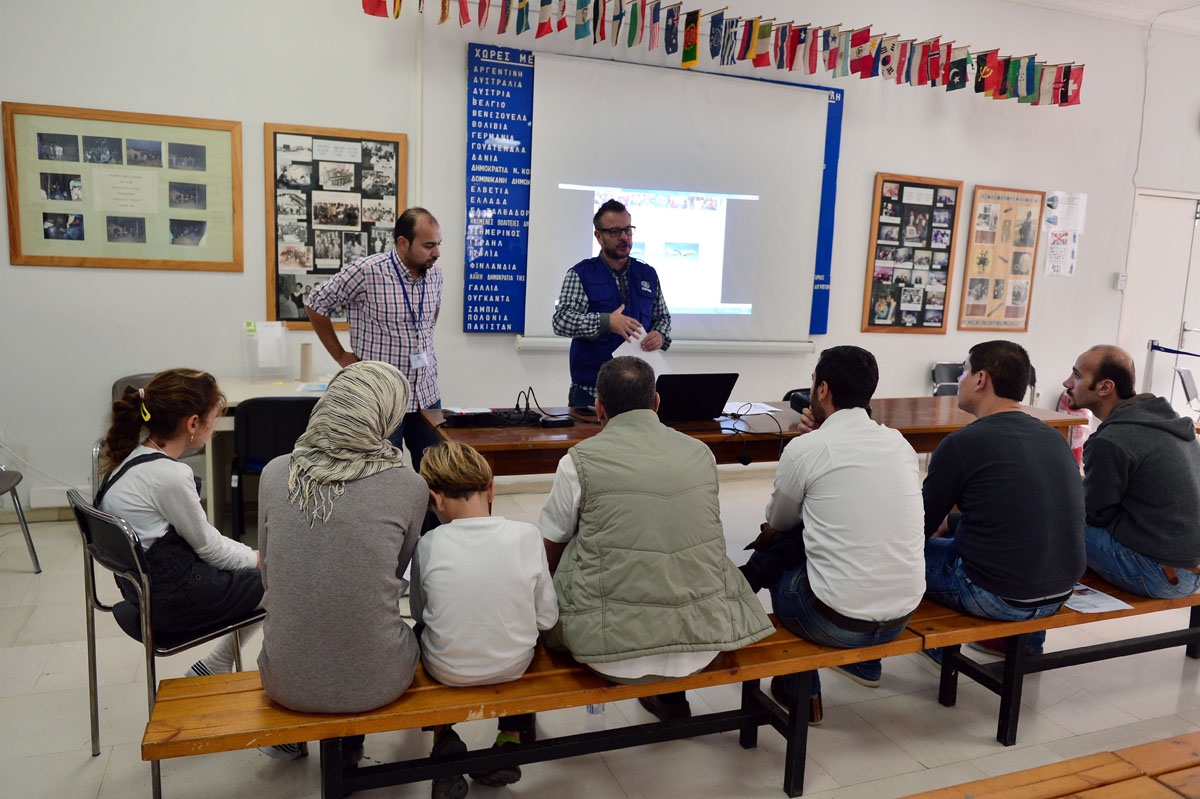 Refugees, who are to be relocated to Portugal, attend an information session at the premises of the International Organisation for Migration (IOM) in Athens on November 9, 2016.