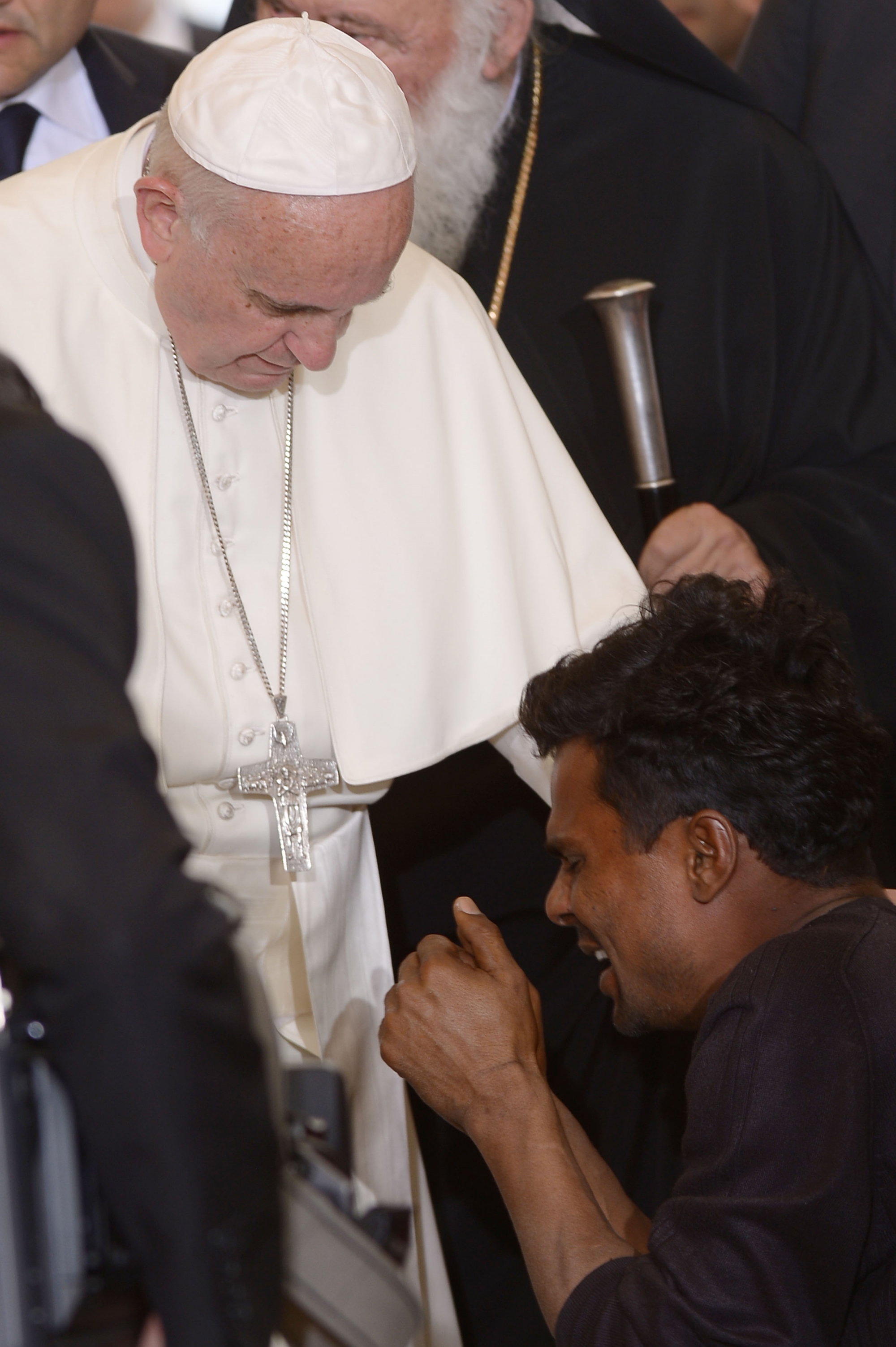 Pope Francis blesses a man kneeling in front of him as he hreets migrants and refugees at the Moria refugee camp on April 16, 2016 near the port of Mytilene, on the Greek island of Lesbos. 