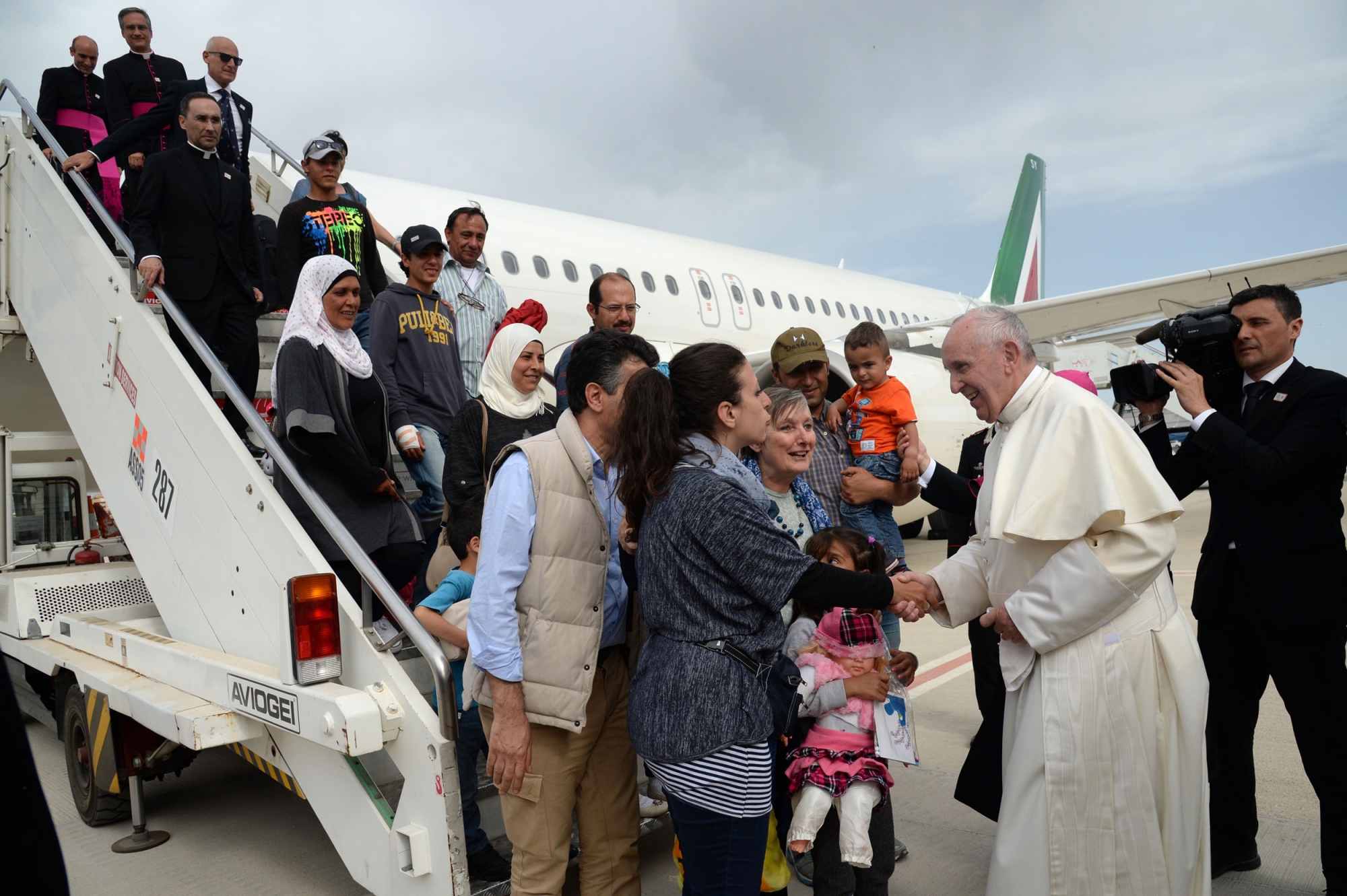 Pope Francis welcomes a group of Syrian refugees after landing at Ciampino airport in Rome following a visit at the Moria refugee camp on April 16, 2016 in the Greek island of Lesbos Pope Francis welcomes a group of Syrian refugees after landing at Ciampino airport in Rome following a visit at the Moria refugee camp on April 16, 2016 in the Greek island of Lesbos