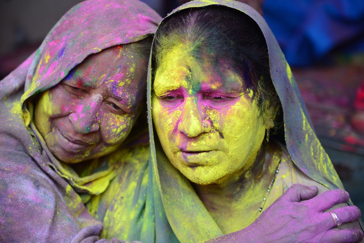 Indian widows celebrate Holi or the festival of colors in Vrindavan on March 9, 2017. Widows congregated on a small patio of the Govinath temple in which they live and danced and played with colored powder to celebrate the occasion. / AFP