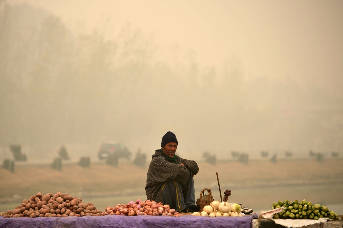 A vegetable vendor waits for customers on the banks of Dal lake in Srinagar on November 22,2016.