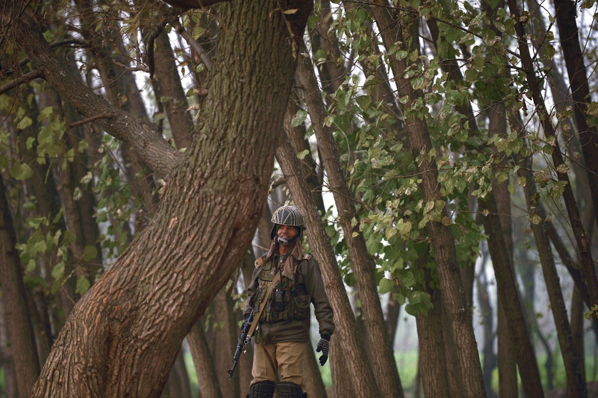 Indian paramilitary trooper stands guard on the shores of Dal Lake on a cold, winter's day in Srinagar on November 23, 2016.