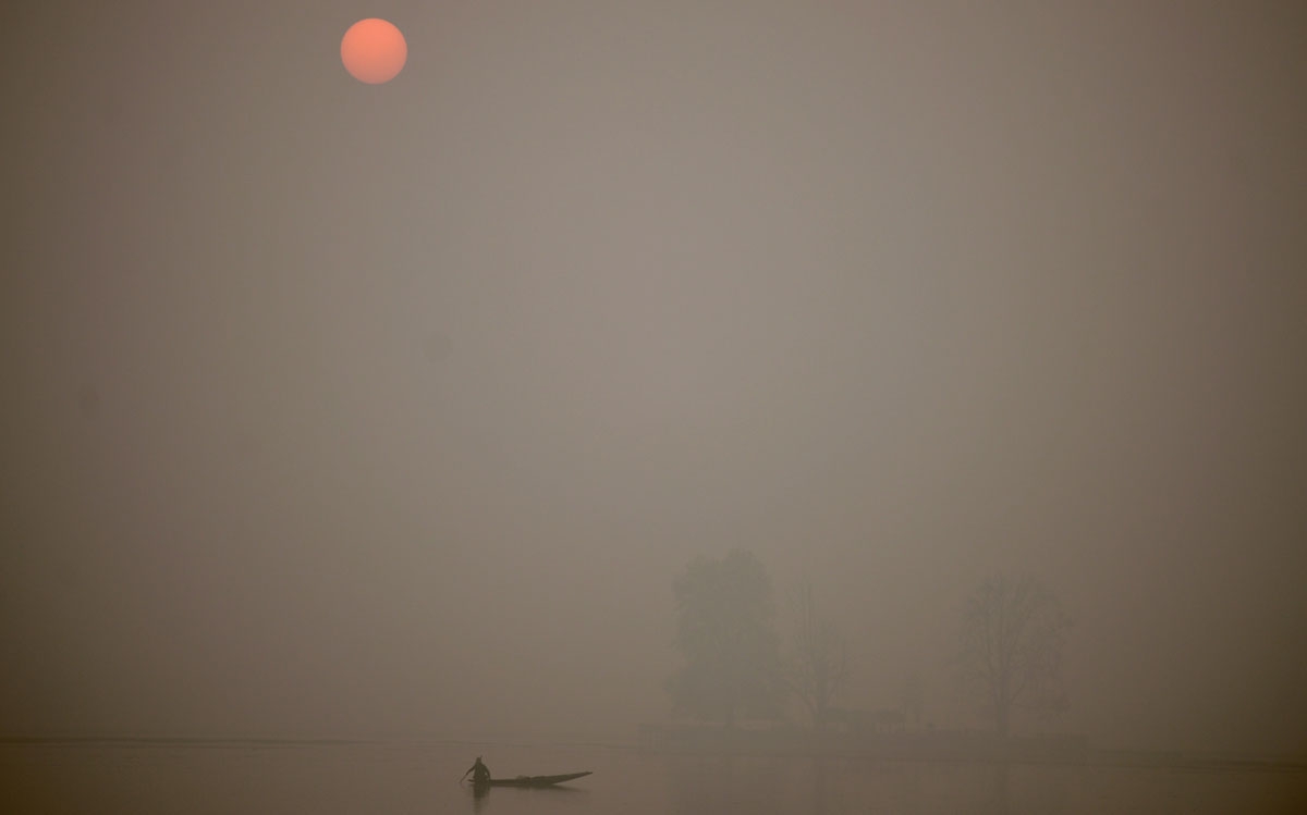 A Kashmiri fisherman rows his boat on Dal Lake at sunset on a cold, winter day in Srinagar on November 23, 2016.