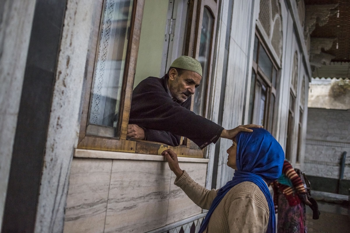 In this photo taken on November 4, 2015, a Kashmiri 'pir', or faith healer offers prayers as he blesses a woman inside the Makhdoom Sahib Shrine in Srinagar.
