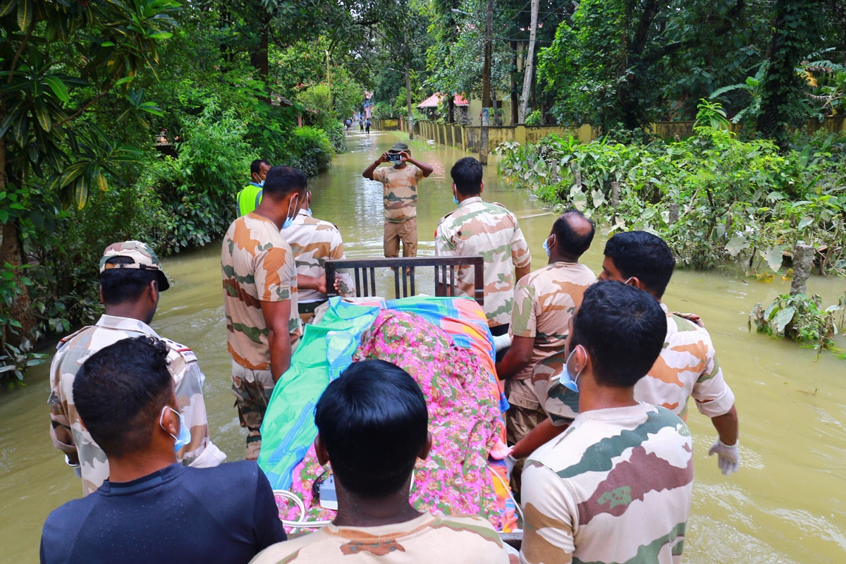 Indian rescue workers transport a bed with an elderly sick woman, Chenagannur, Kerala, August 20, 2018.