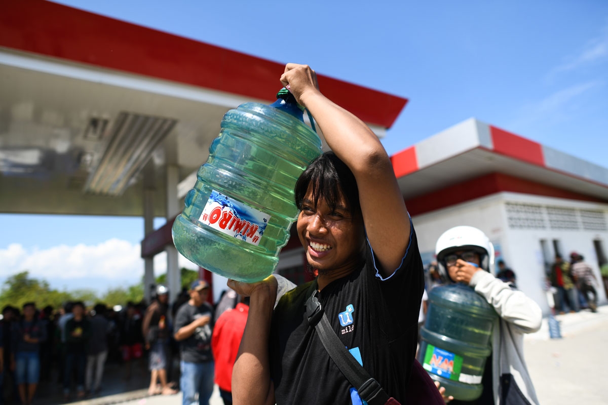Carrying gasoline in water containers, Palu, October 1, 2018.