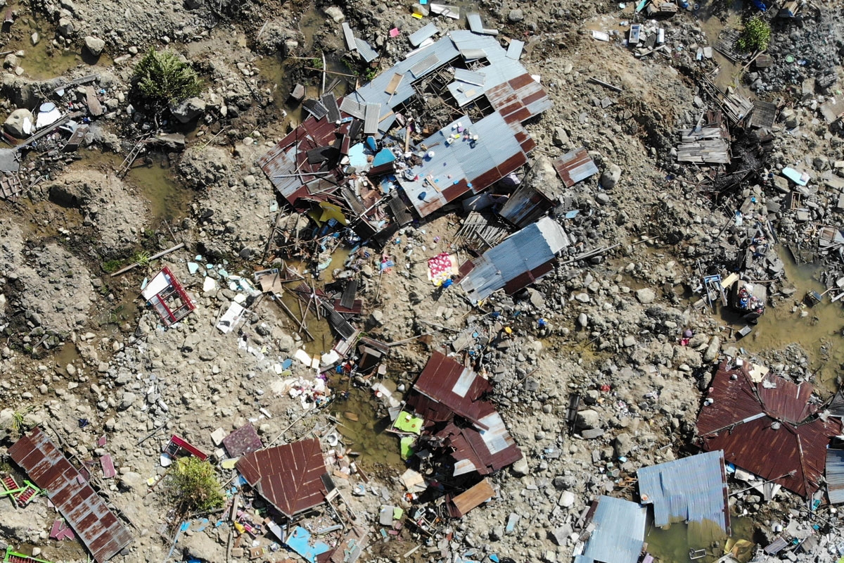 Survivors salvage useable items from the debris of a destroyed house in Palu, Indonesia's Central Sulawesi on October 2, 2018.