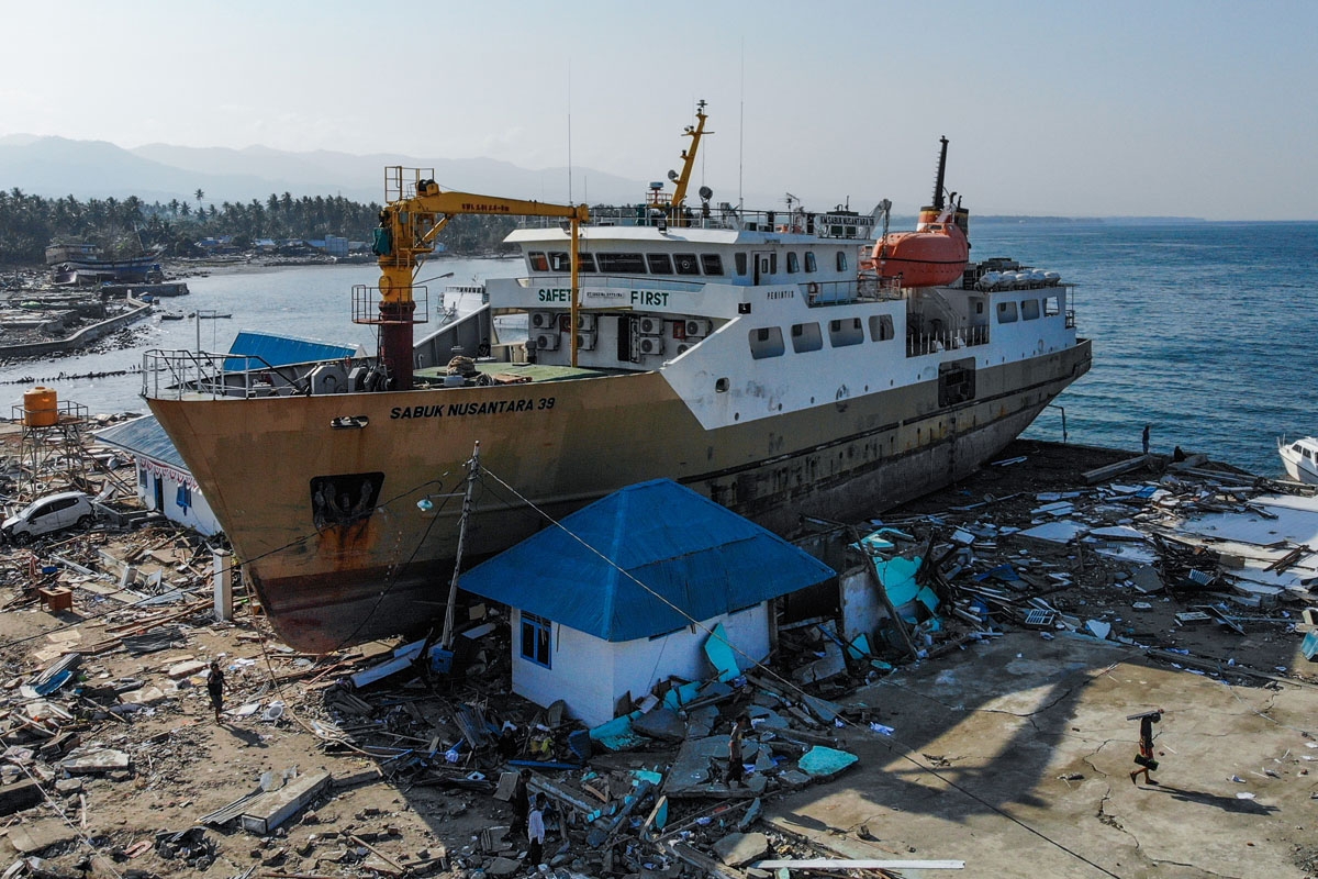 This aerial photograph taken on October 3, 2018 shows a passenger ferry that was washed ashore into buildings in Wani, Indonesia's Central Sulawesi, after an earthquake and tsunami hit the area on September 28. - Nearly 1,400 people are now known to have