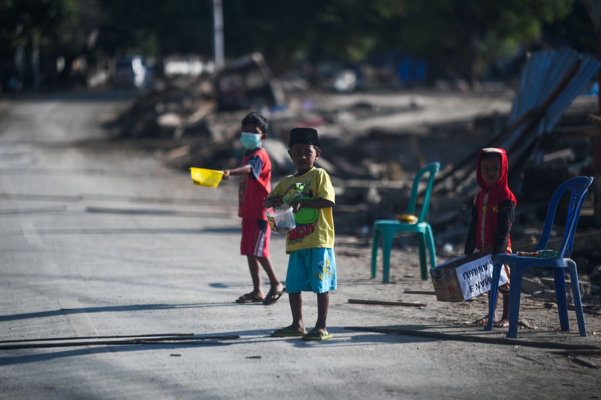 Children beg along a road in Donggala in Indonesia's Central Sulawesi on October 5, 2018.