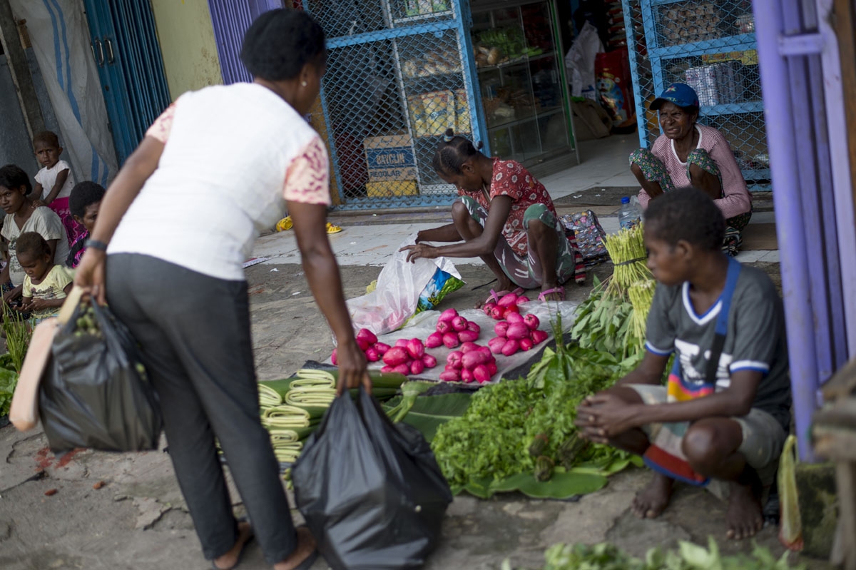 A Papuan woman shops for vegetables at street market in Timika in Indonesia's easternmost Papua province, on January 25, 2018.