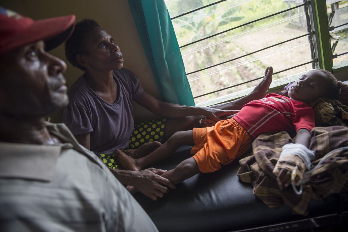 A Papuan couple accompany their sick children at local clinic Ayam village in Asmat district in Indonesia's easternmost Papua province on January 26, 2018.