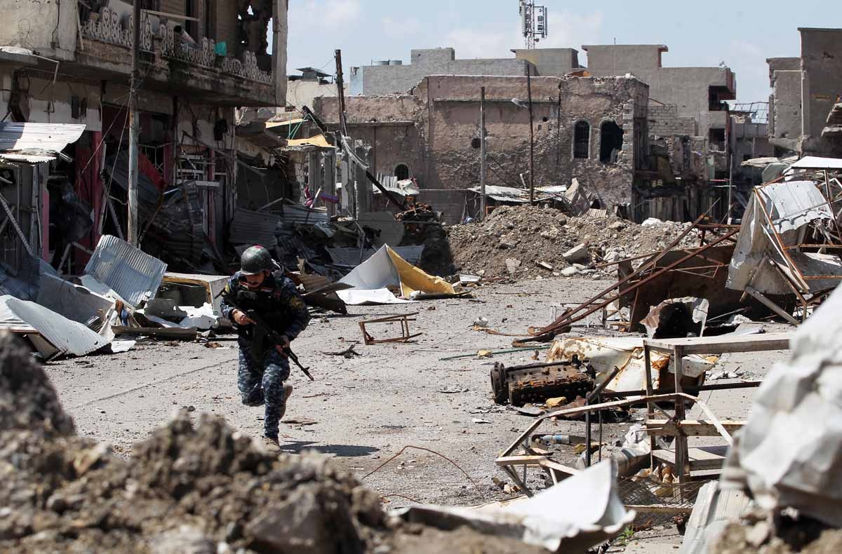 A member of the Iraqi forces manoeuvres through the rubble in a street in the old city of Mosul on April 15, 2017, during an offensive to recapture the city from Islamic State (IS) group fighters.