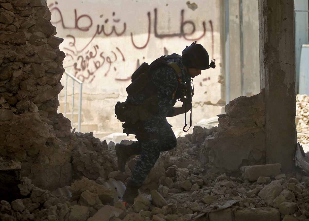 An Iraqi forces member runs for cover as they fight Islamic State (IS) group fighters on June 19, 2017 during a battle to retake the last district of the Old City of Mosul still held by the jihadists.