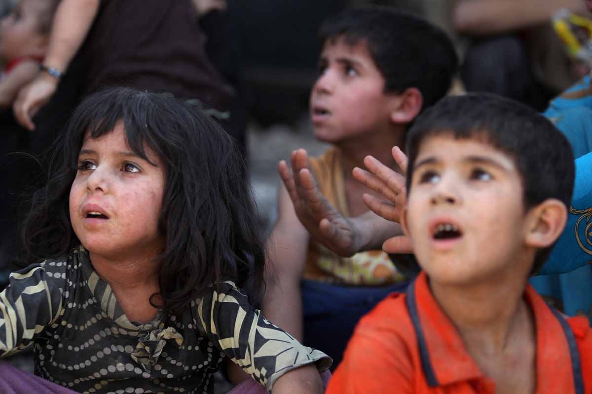 Iraqi children rest on their way, while fleeing from the Old City of Mosul on July 5, 2017, during the Iraqi government forces' offensive to retake the city from Islamic State (IS) group fighters.