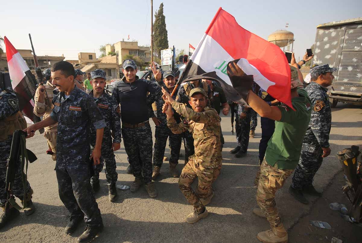 Iraqi federal police members celebrate in the Old City of Mosul on July 9, 2017 after the government's announcement of the liberation of the embattled city.