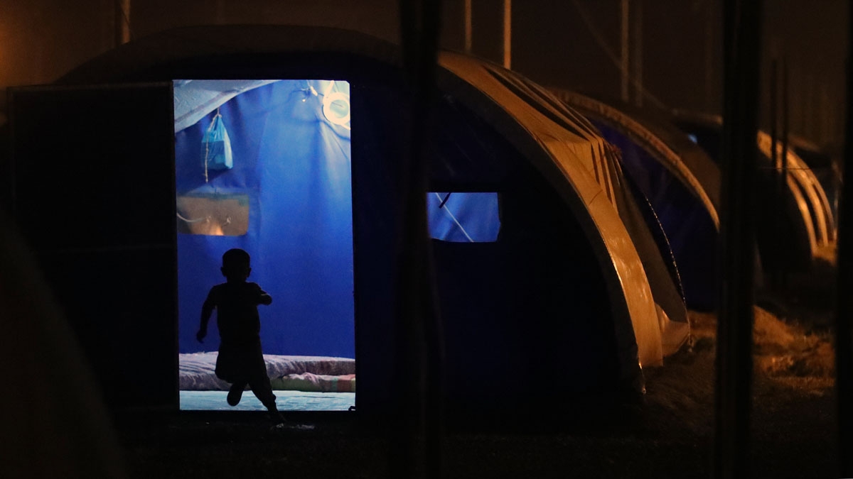 A child runs outside a tent after sunset on the first fasting day of the Muslim holy month of Ramadan, at al-Khazir camp for the internally displaced, located between Arbil and Mosul, on May 27, 2017