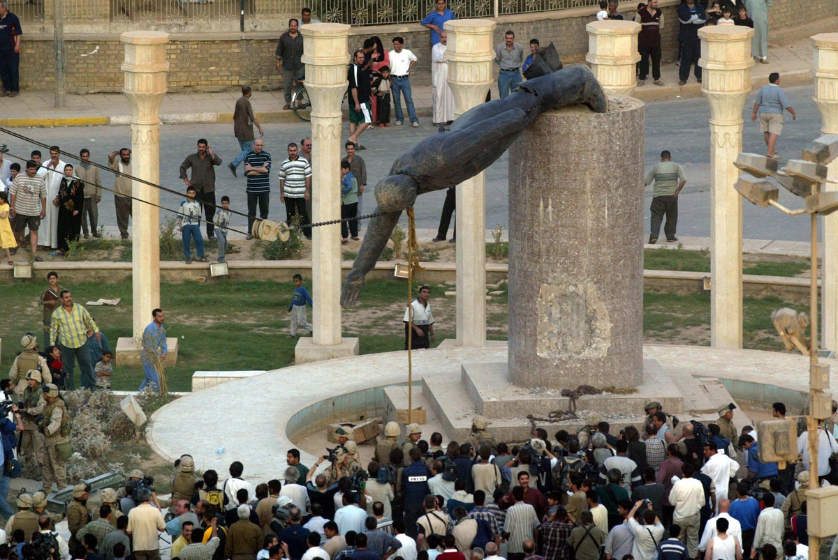 (FILES) In this file photo taken on April 9, 2003 Iraqis watch a statue of Iraqi President Saddam Hussein falling in Baghdad's al-Fardous (paradise) square.