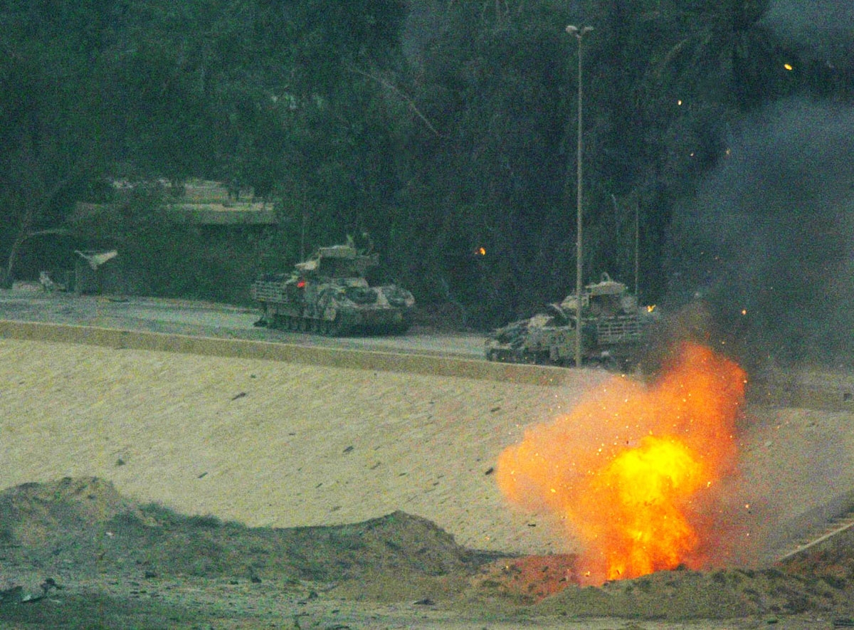 US Bradley amored vehicles clear Iraqi Republican Guard bunkers on the road around Baghdad's main presidential palace compound 07 April 2003.