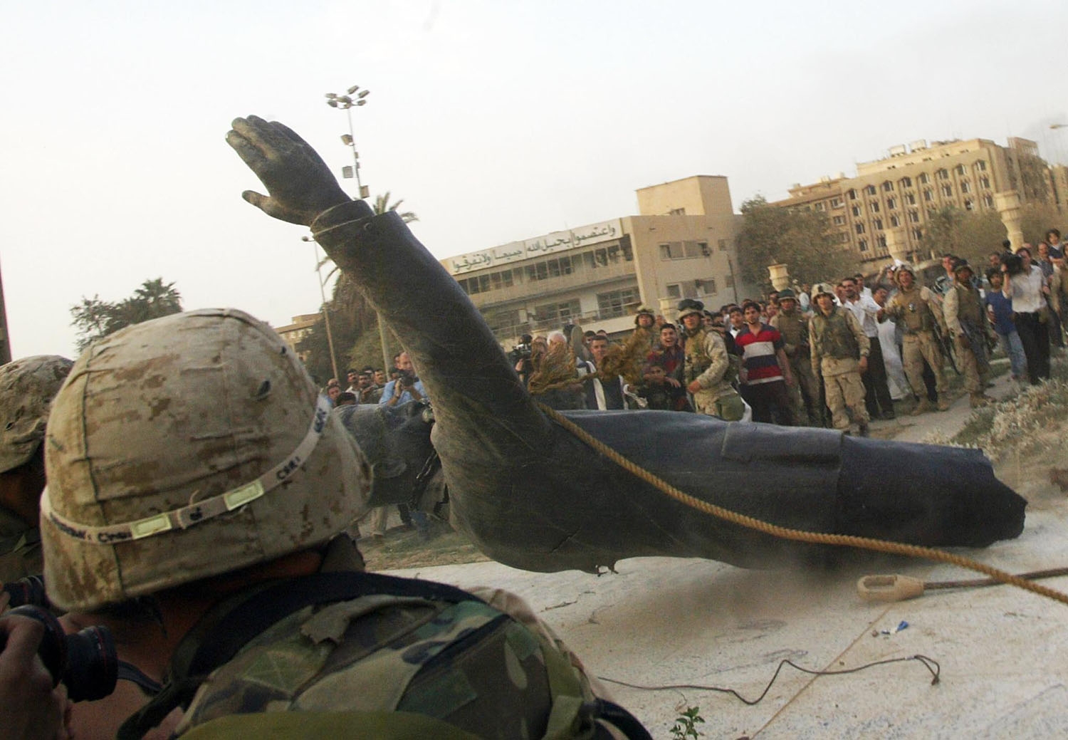 (FILES) In this file photo taken on April 9, 2003, a statue of Saddam Hussein falls as it is pulled down by a US armoured vehicle in Baghdad's al-Fardous square.