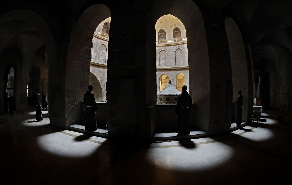 Des moines franciscains surplombent le Tombeau de Jésus, dans la basilique du Saint-Sépulcre, le 17 février 2018.