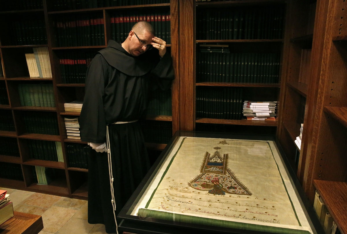 Le moine Franciscain Serge Loktionov montre un firman, un décret émis par le sultan de l'empire ottoman Othman Khan III, datant de 1757 et autorisant les Franciscains à prier sur le Tombeau de Jésus et la Pierre de l'Onction. Couvent du Saint-Sauveur, Jér