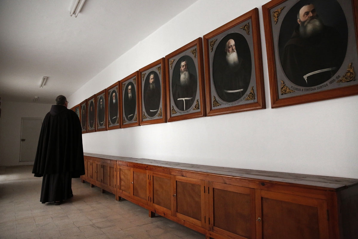 Un moine franciscain dans la salle des portraits des Custodes, les ministres provinciaux de l'ordre qui se sont succédé avec juridiction sur l'ordre dans la région. Couvent Saint-Sauveur. Jérusalem. 25 janvier 2018.