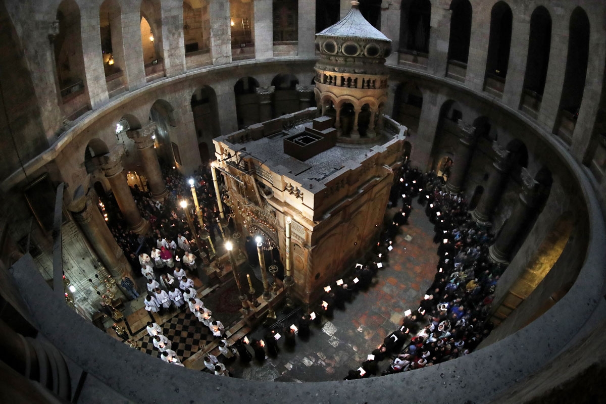 Des moines franciscains prient et chantent pendant les fêtes de Carême, autour du Tombeau de Jésus, dans la basilique du Saint-Sépulcre, le 17 février 2018. (AFP / Thomas Coex)