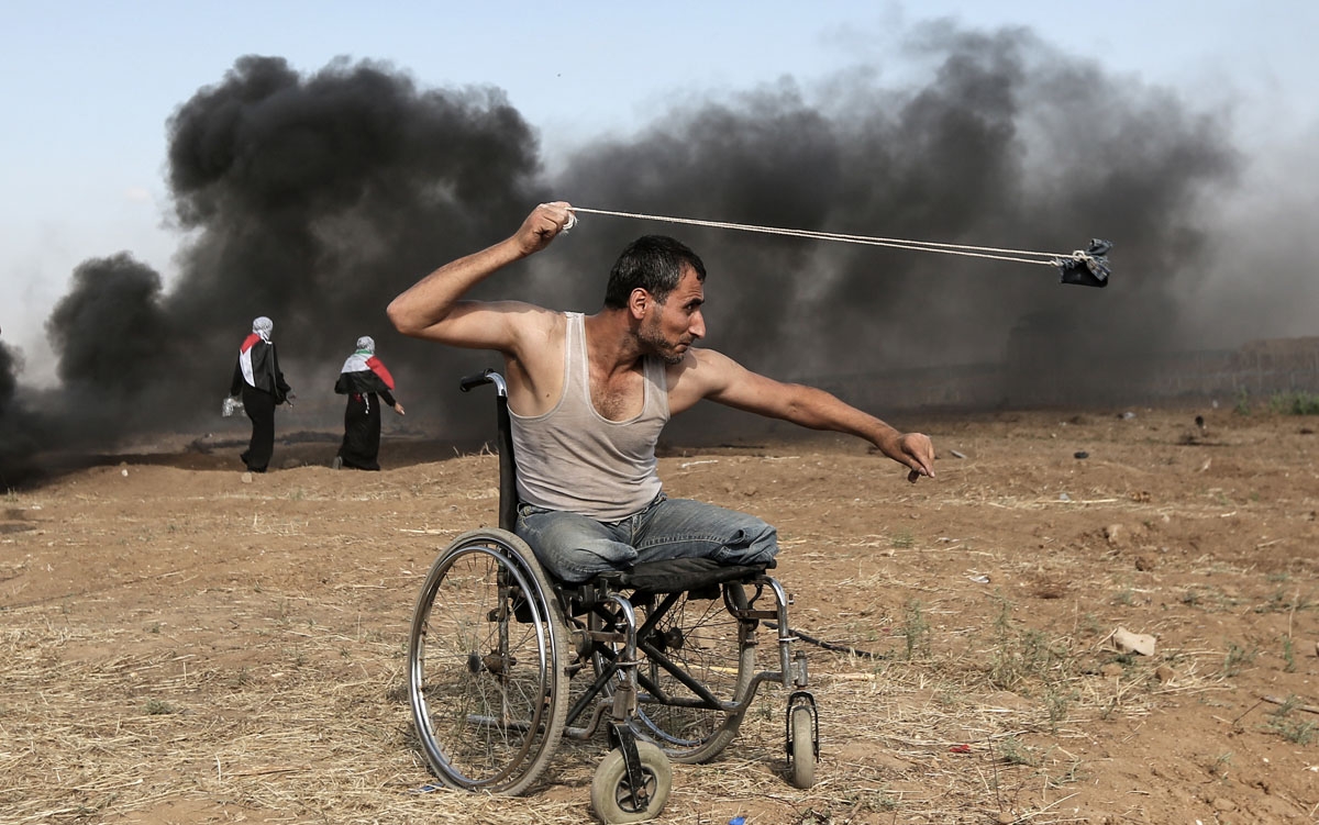 Palestinian Saber al-Ashkar, 29, hurls rocks during clashes with Israeli forces along the border with the Gaza strip, east of Gaza City, on May 11, 2018, as Palestinians demonstrate for the right to return to their historic homeland in what is now Israel.