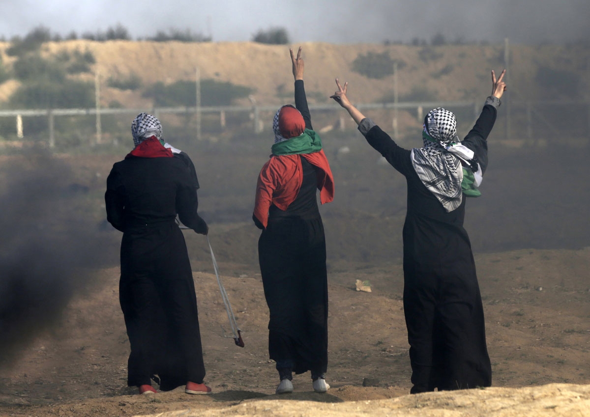 Palestinian women flash the victory gesture as they stand before the fence with Israel during a demonstration along the border with the Gaza strip east of Gaza city on June 1, 2018. (Photo by Mahmud Hams / AFP)