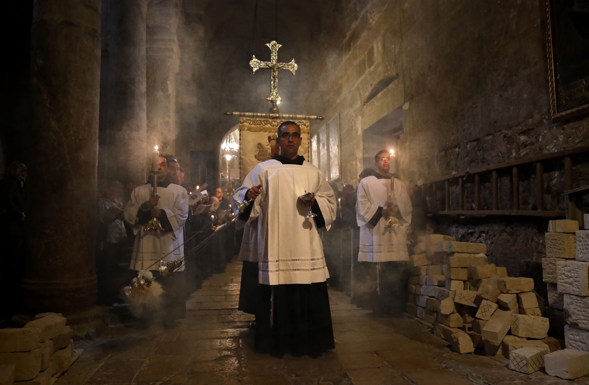 Franciscan friars pray during the Lenten procession inside the Church of the Holy Sepulchre in the Old City of Jerusalem, on February 17, 2018.