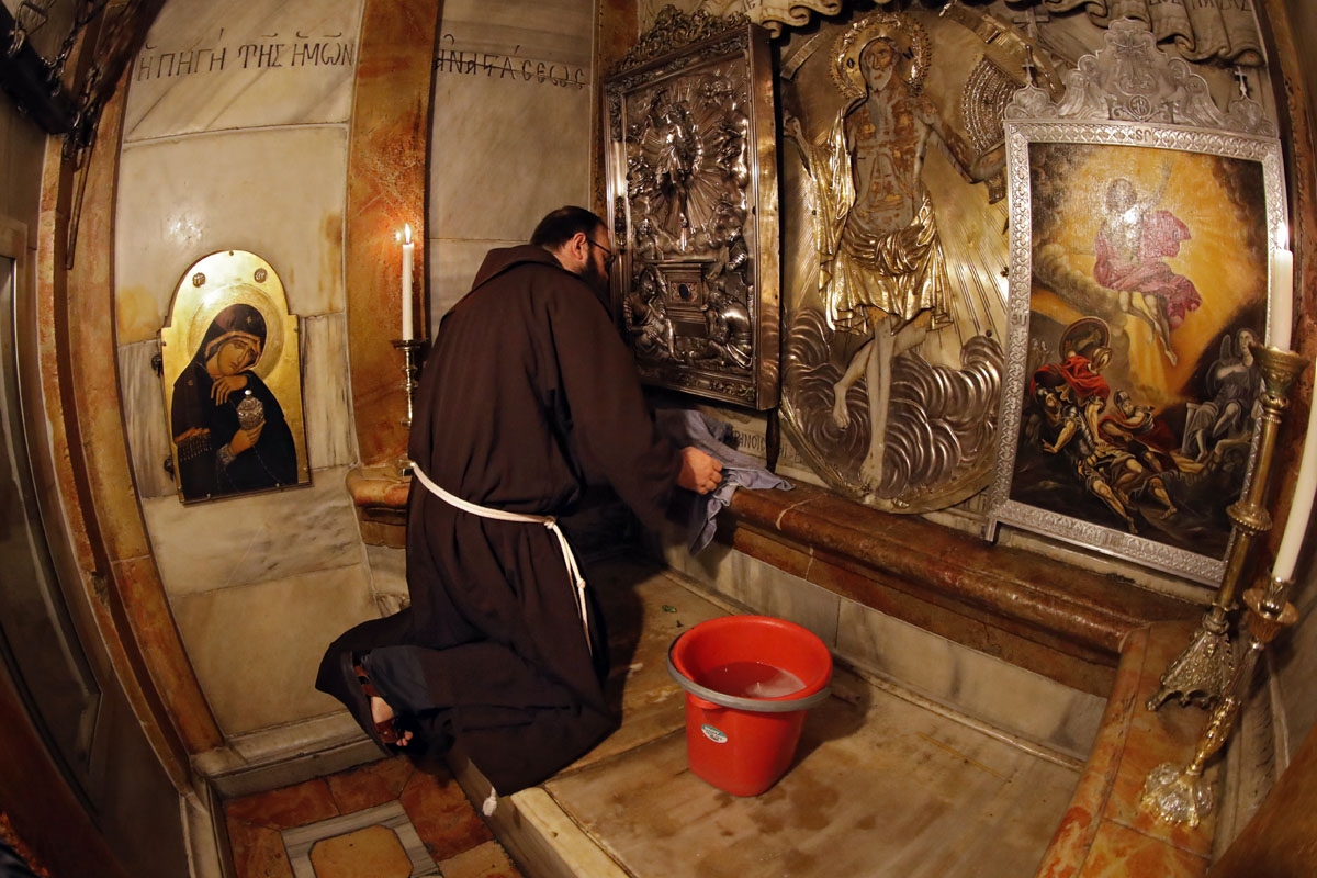 Croatian friar Sinisa Srebrerovic cleans the ornaments inside a tomb believed to the burial site of Jesus Christ on March 2, 2018. Dispatched to the city 800 years ago by the Catholic order's founder, Saint Francis of Assisi, the Franciscans have for c