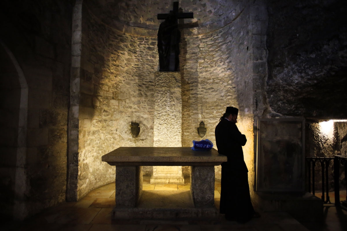 An Armenian priest prays inside the Armenian Chapel of Saint Helena in The Church of the Holy Sepulchre, also known as the Basilica of the Resurrection, one of Christianity's holiest sites in Jerusalem's old city on April 7, 2014.