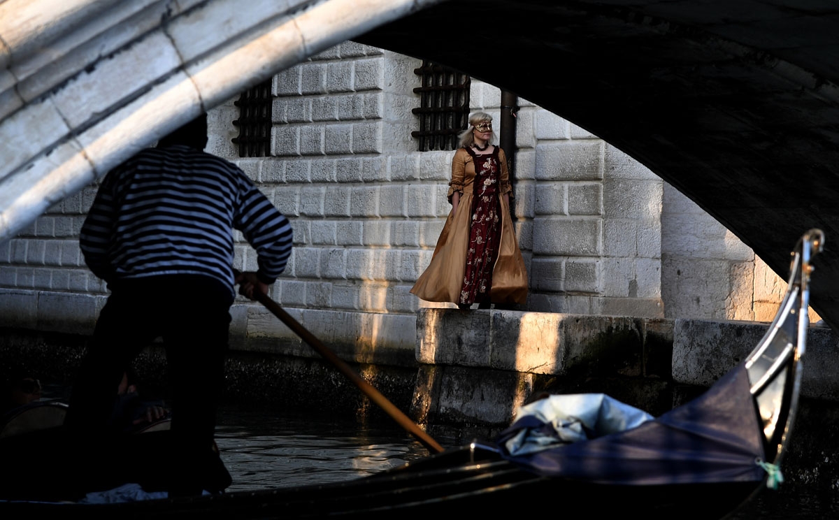 masked woman wearing a traditional carnival costume walks in the streets of Venice, during Venice's Carnival on February 4, 2018.