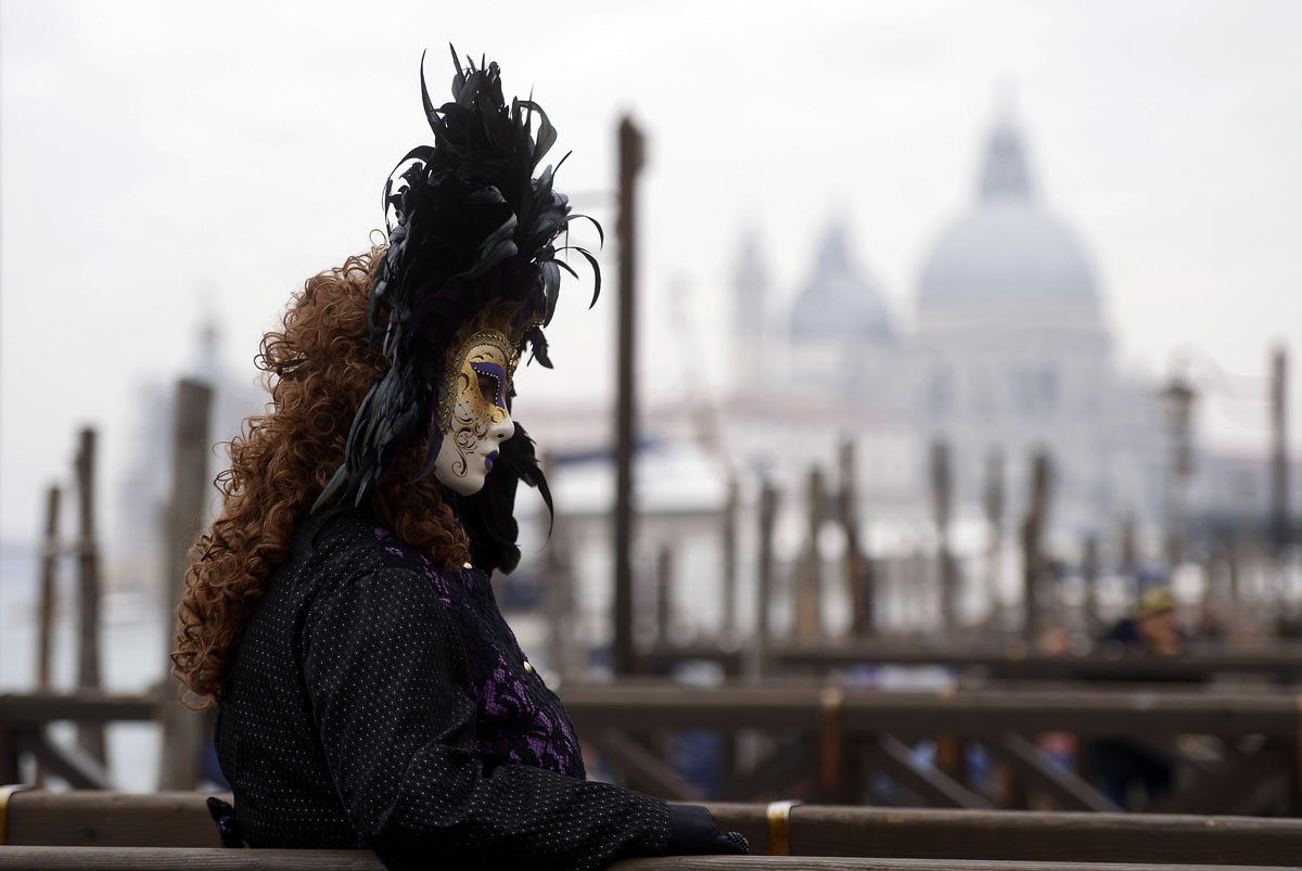 A masked reveller dressed in a period costume takes part in the Venice Carnival on January 27, 2018.