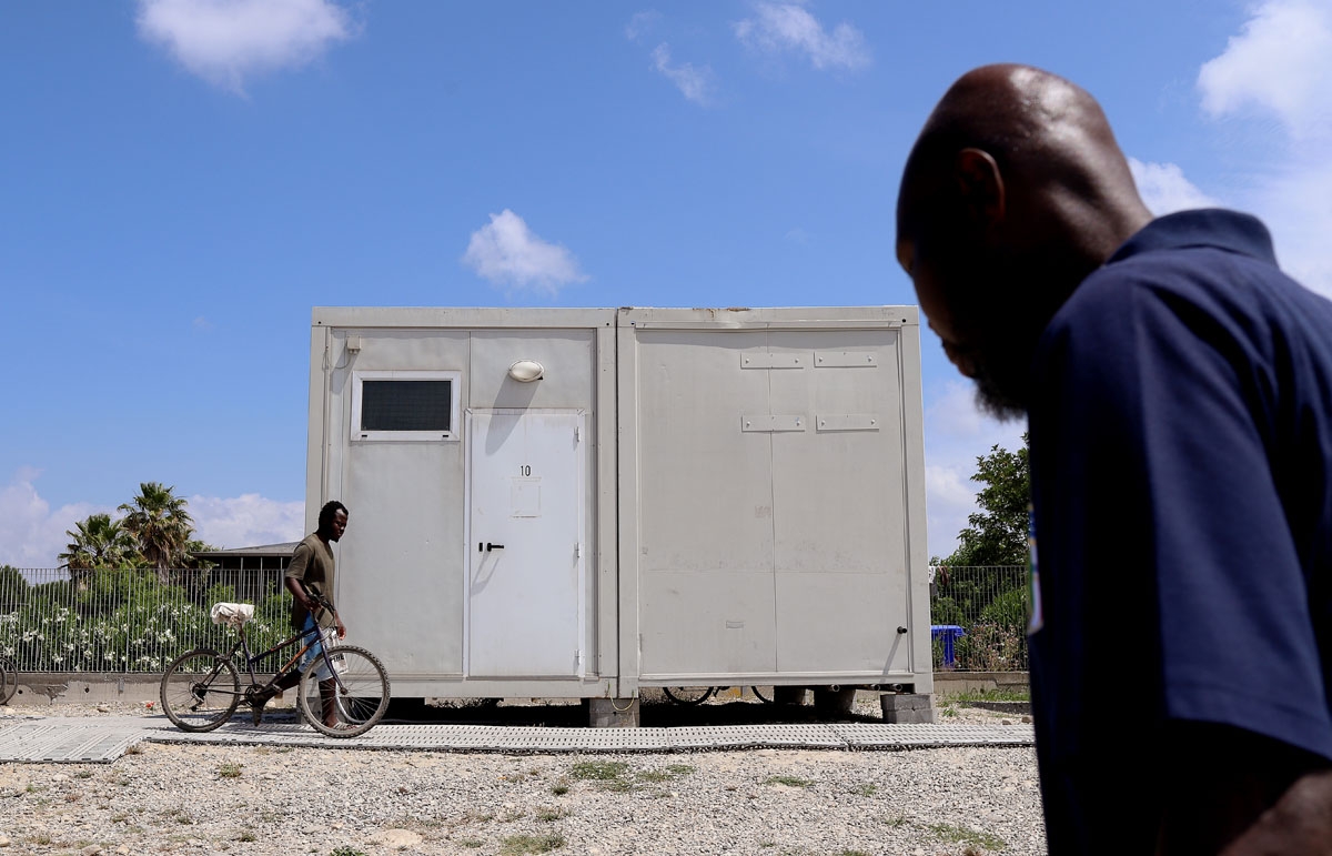 A man walks on June 5, 2018, in a migrant tent camp in the village of San Ferdinando, near Gioia Tauro, in the southern Italian region of Calabria.