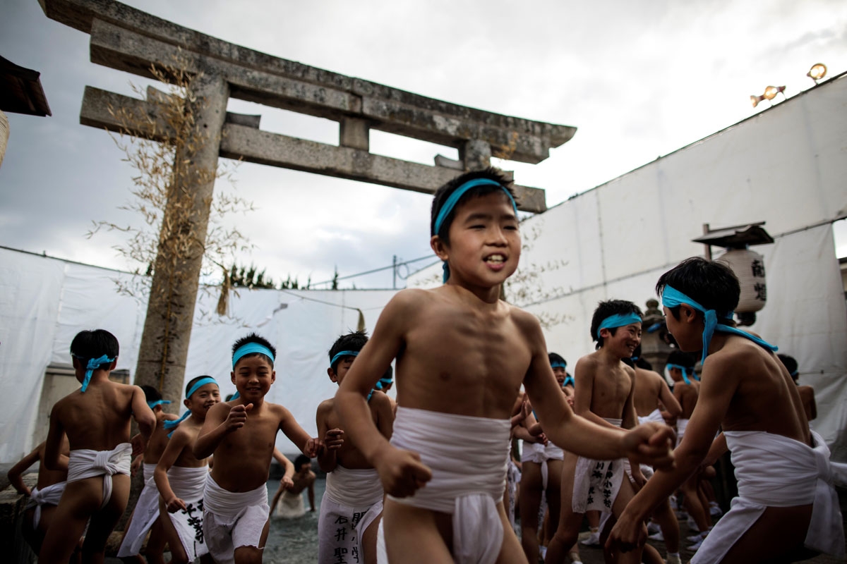 In this picture taken on February 18, 2017, Japanese boys step out of the fountain after being purified during the boys' event in the annual Naked Man Festival or 'Hadaka Matsuri'at Saidaiji Temple in Okayama, western Japan.