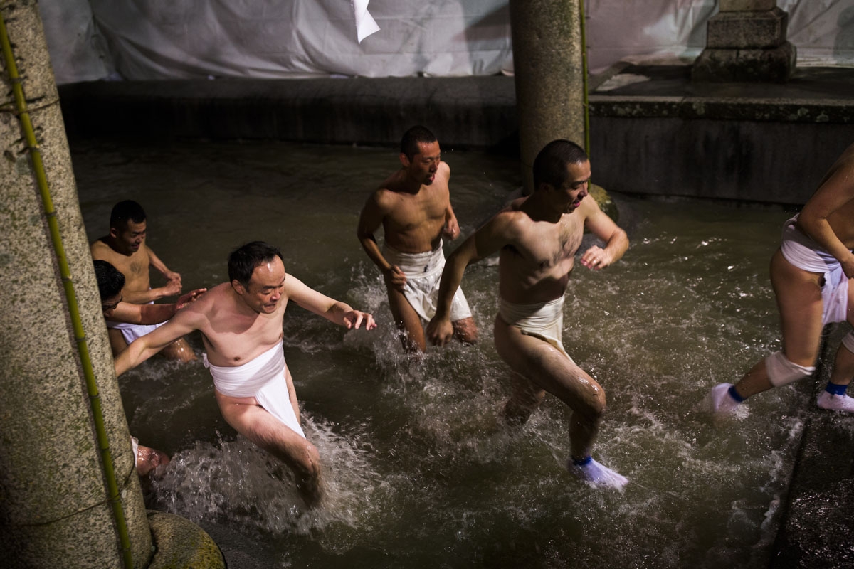 In this picture taken on February 18, 2017, worshippers step out of a fountain after being purified during the annual Naked Man Festival or 'Hadaka Matsuri' at Saidaiji Temple in Okayama, western Japan.