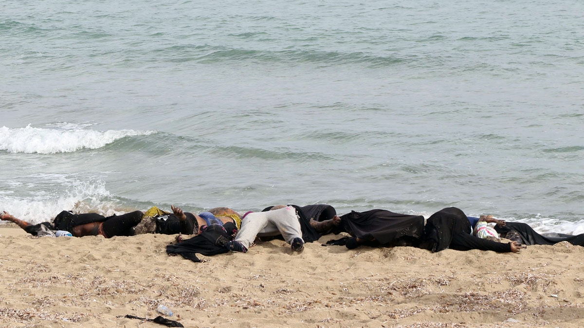 he bodies of illegal migrants are seen lying on the beach in Garabulli, east of the capital Tripoli, on October 6, 2016 after their boat capsized off the shore of Libya.