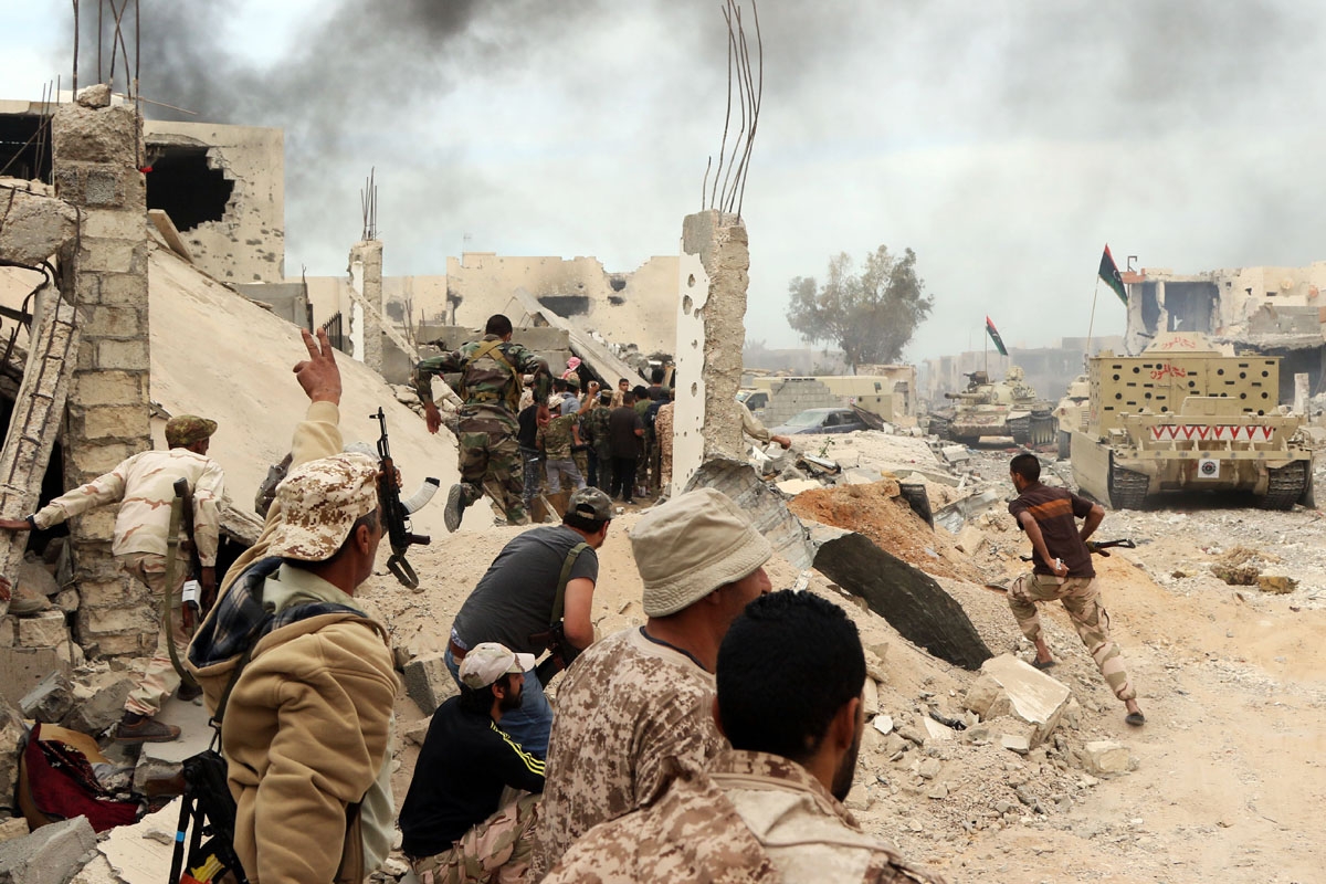 Forces loyal to Libya's Government of National Accord (GNA) hold a position amid the rubble of destroyed buildings in Sirte's Al-Giza Al-Bahriya district on November 21, 2016, during clashes with Islamic State (IS) group jihadists to retake control of the